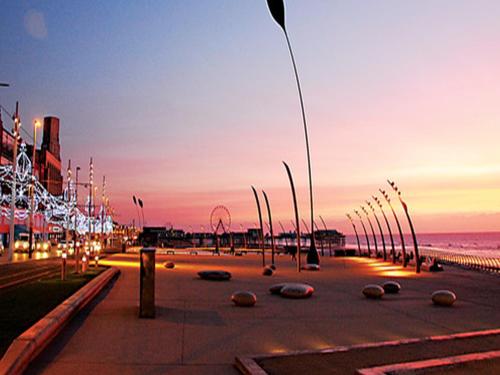 布莱克浦海边拉斯帕尔马斯酒店 的日落时分海滩上一条灯光明亮的街道