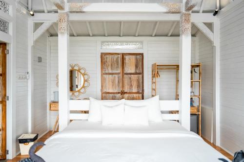 珀尼达岛Mambo Hill Resort的白色卧室配有白色床和白色枕头