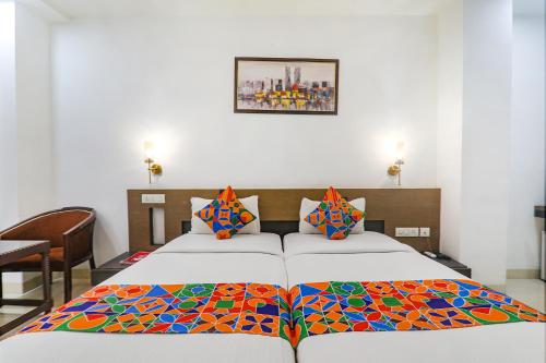 勒克瑙FabHotel Prime The Continental的一间卧室配有两张床和彩色毯子