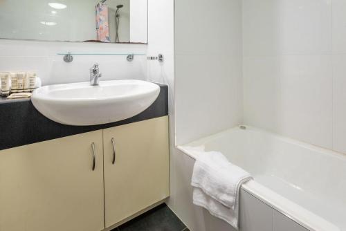 布里斯班Sleek Urban Oasis with Balcony的浴室配有盥洗盆和浴缸。