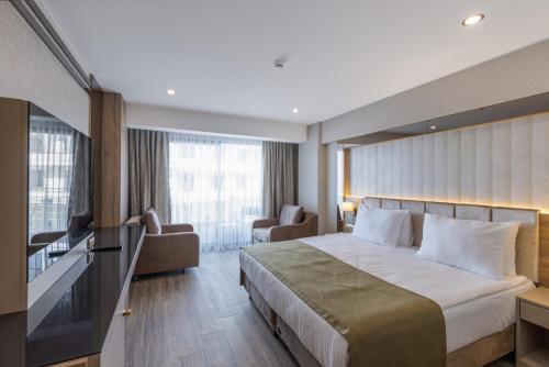 贝莱克Belenli Resort Hotel的一间设有大床和窗户的酒店客房