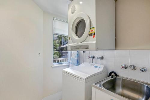 亚历山德拉岬角亚历克斯海洋图腾酒店的厨房配有水槽和洗衣机