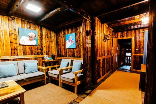 三江三江南夷民宿的配有木墙、椅子和桌子的客房