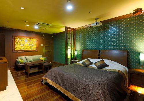 香芝市ホテルウォーターゲート香芝的一间卧室配有一张床、一张沙发和一张桌子
