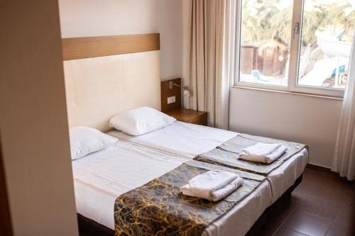 锡德Akalia Suite Hotel & SPA的一间卧室配有一张床,上面有两条毛巾