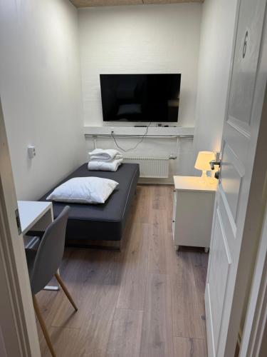 奥尔堡Italian Rooms 6的小房间设有一张床和一台平面电视