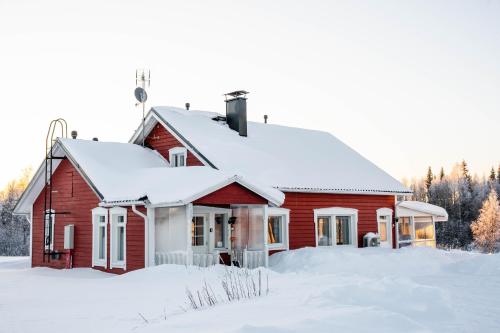 RaiskioHommala的屋顶上积雪的红色房子
