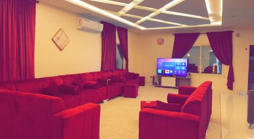 阿哈达Flowers of Al hada的客厅配有红色沙发和平面电视