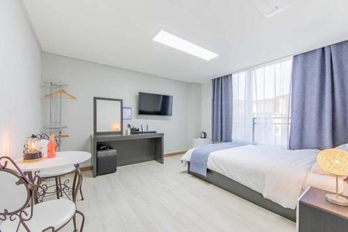 丽水市Jin Arirang Hostel的酒店客房带一张床、一张桌子和椅子