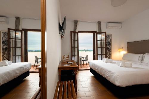 阿尔加尔Hotel Tugasa Villa de Algar的酒店客房设有两张床和一个阳台。