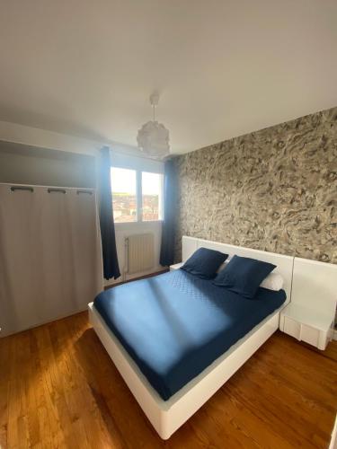 LempdesAppartement spacieux avec parking的一间卧室配有一张带蓝色床单的大床