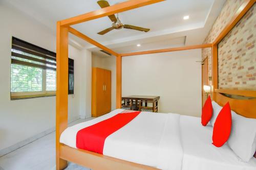 加尔各答Super OYO Krishna Guest House的一间卧室配有红色枕头的床