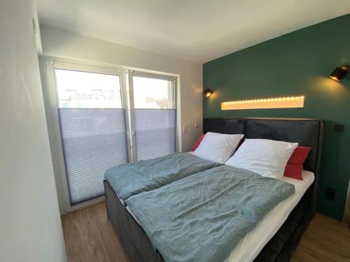 科布伦茨Moselblick Penthouse mit Terrasse的卧室内的一张床位,卧室设有绿色的墙壁