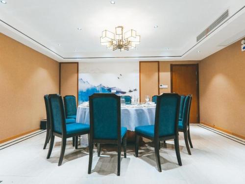 武汉ZMAX Hotels Wuhan East Lake的一间带桌椅和吊灯的用餐室