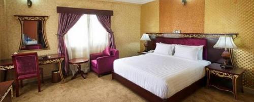奥韦里Top Rate Hotel的配有一张大床和镜子的酒店客房