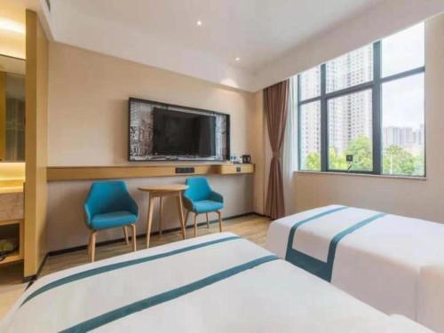 昆明City Comfort Inn Kunming Qianxing Road Dashanghui Children's Hospital的酒店客房设有两张床和一台平面电视。