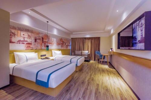 贵阳City Comfort Inn Guiyang Airport Future Ark的酒店客房设有两张床和一台平面电视。