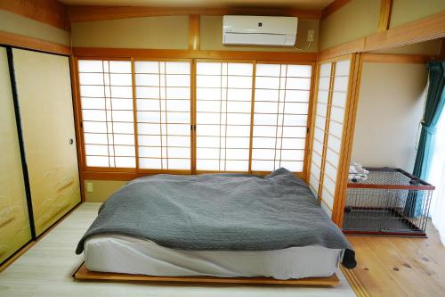 Ioki宿や晴的一间设有床铺的卧室,位于带窗户的房间内