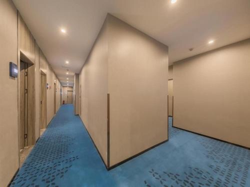 重庆7 Days Premium Hotel Chongqing Jiefangbei No.1 Bridge Hongyadong的一条铺有蓝色地板的走廊和一排门