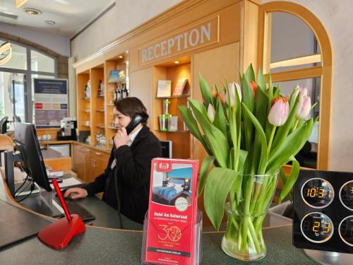 爱尔福特皇帝大厅酒店的花瓶装的商店里的一个女人在电话上说话