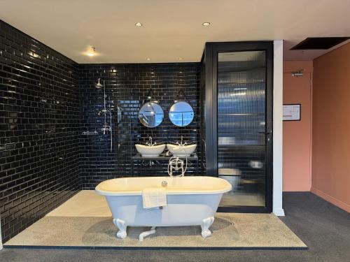 开普敦Neighbourgood Loop Street的浴室配有浴缸及三面镜子