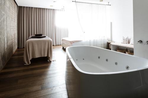 马莱斯韦诺斯塔白十字酒店的带浴缸的客房内配有桌子
