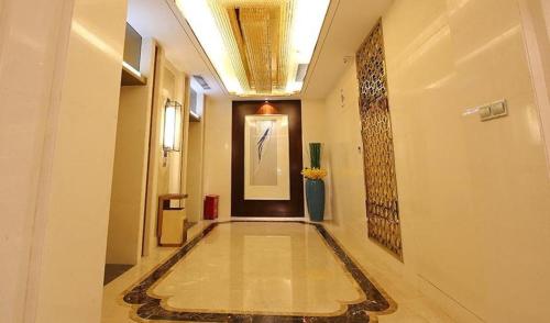 海口Xingtai Yuehai Hotel的大楼内铺着瓷砖地板的走廊