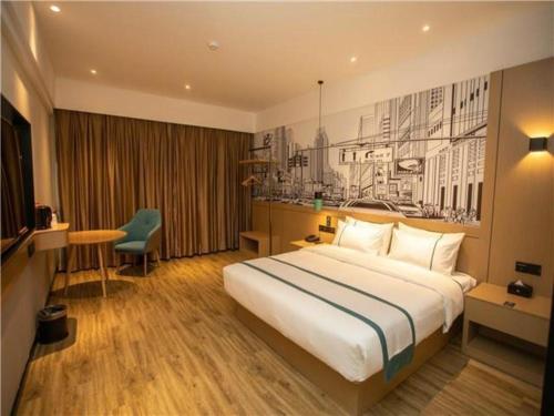 江都City Comfort Inn Yangzhou Jiangdu North Limin Road的酒店客房设有一张大床和一张书桌。
