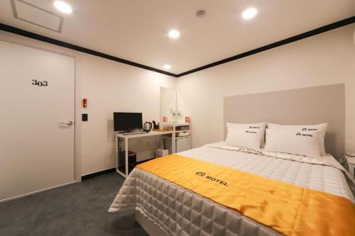 釜山Prince Motel的一间卧室配有一张床和一张带电脑的书桌