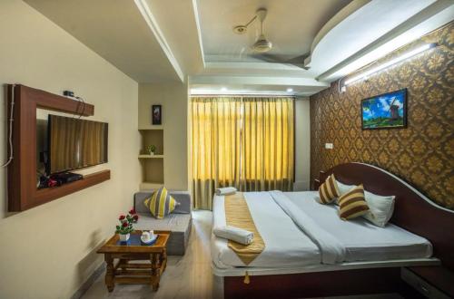 古瓦哈提Asian Suites Guwahati的一间卧室配有一张床和一个沙发