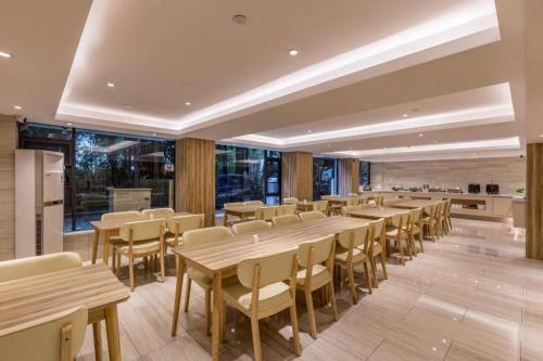 JiangtouzhenHanting Premium Hotel Xiamen SM Plaza Songbo的用餐室配有木桌和椅子