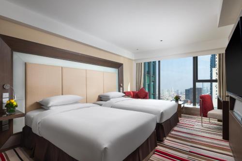 南京南京新街口苏宁诺富特酒店的有一排床位,位于酒店带窗户的房间里