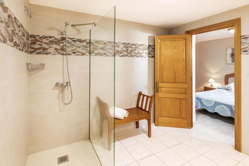 苏昂博Villa Ponent的带淋浴、椅子和床的浴室