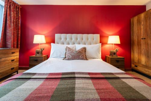 NewickThe Bull on the Green的卧室配有白色的床铺和红色的墙壁