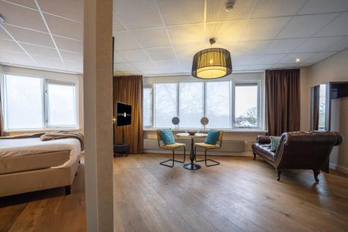 米德尔堡Fletcher Hotel-Restaurant Arneville-Middelburg的酒店客房带一张床、一张桌子和椅子