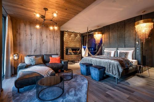 GrainetHüttenhof - Wellnesshotel & Luxus-Bergchalets - Adults only的一间卧室配有一张床和一张沙发