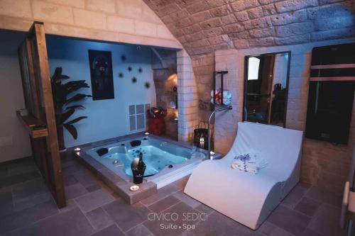 阿尔塔穆拉Civico Sedici Suite & Spa的一间带浴缸、椅子和浴缸的浴室。