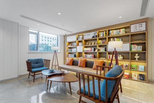 福山Hanting Premium Hotel Yantai Development Zone Golden Beach的带沙发和书架的客厅