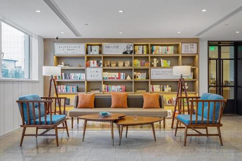 福山Hanting Premium Hotel Yantai Development Zone Golden Beach的客厅配有沙发、椅子和书架