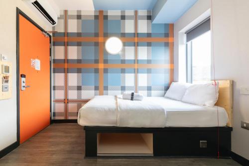 格拉斯哥格拉斯哥便捷酒店的一间卧室配有一张床和条纹墙