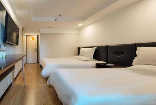 北京Hi Inn Beijing Chaoyangmen的酒店客房设有两张床和一台平面电视。