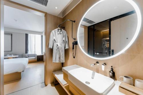 JinzhuzhenJi Hotel Guiyang Guanshan Lake High-Tech Zone的一间带水槽和镜子的浴室