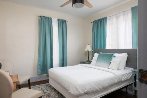 伯明翰East Lake Stunner-Located at the foot of the Ruffner Mountains的卧室配有一张带蓝色窗帘的大型白色床