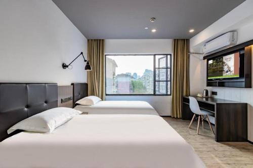 杭州Hi Inn Hangzhou Sijiqing Qiutao North Road的一间带三张床、书桌和电视的卧室