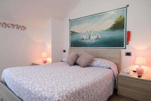 费拉拉达尔帕戈Albergo alla spiaggia的卧室配有一张床,墙上挂有绘画作品