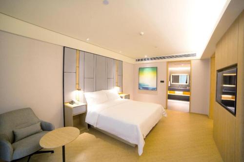 花都Ji Hotel Guangzhou Baiyun Airport的卧室配有白色的床和椅子