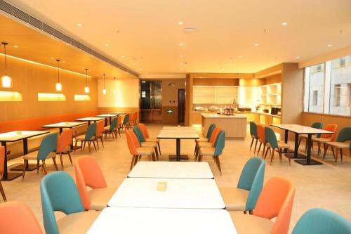 鄂尔多斯Hanting Hotel Ordos Yijinholoqi Wenming Road的一间带桌椅的餐厅和一间厨房