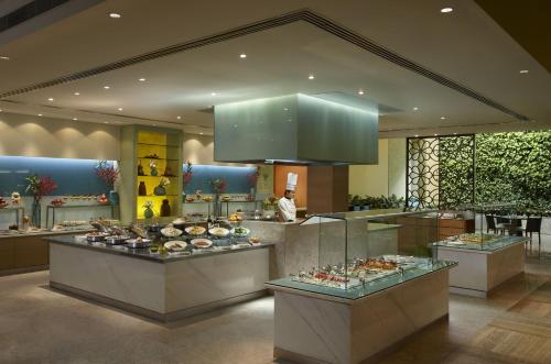 班加罗尔ITC Gardenia, a Luxury Collection Hotel, Bengaluru的展示着一大堆食物的餐厅