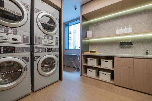 成都Ji Hotel Chengdu 339 Tv Tower的洗衣房配有3台洗衣机和1个柜台