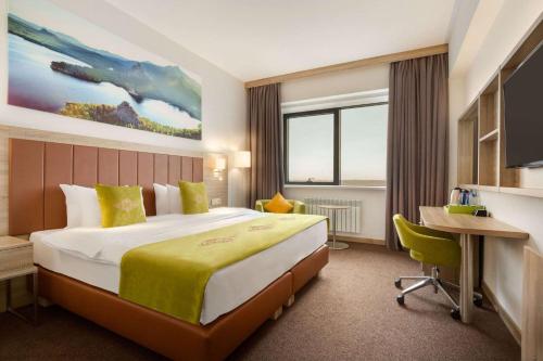 阿斯塔纳温德姆花园阿斯塔纳酒店的酒店客房设有一张大床和一张书桌。